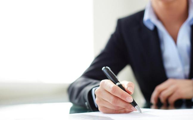 Una mujer firma un contrato de trabajo.