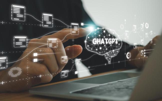 Holograma de ChatGPT proyectado frente a un ordenador.