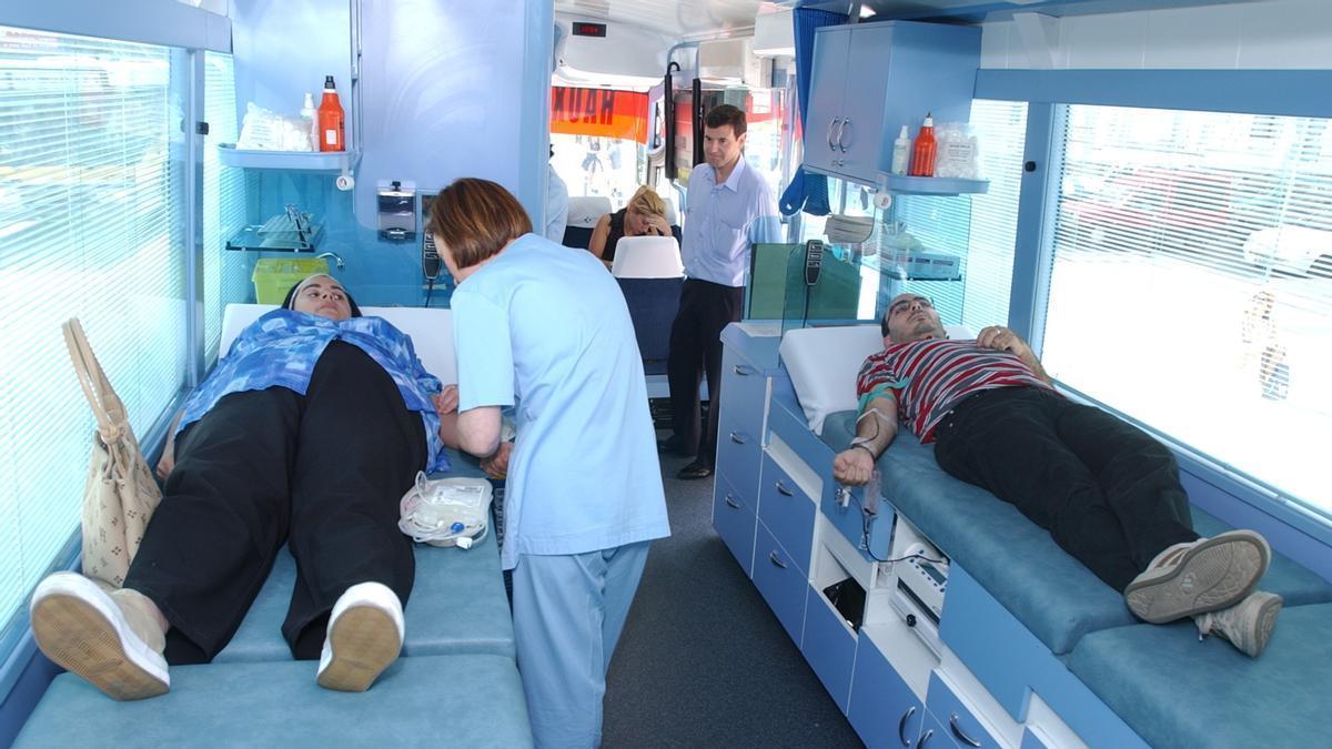 Personas donando sangre en un autobús preparado para ello.