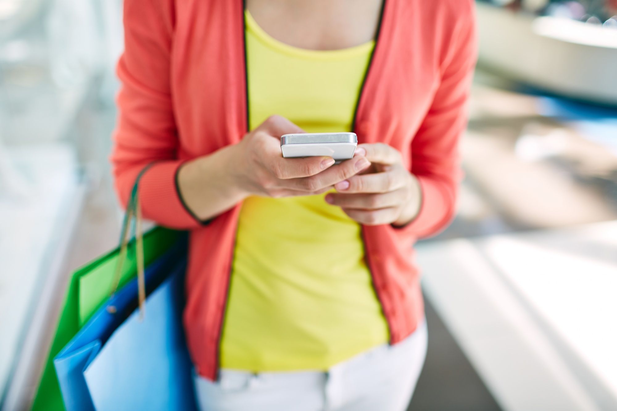 Una mujer revisa su tique digital en el móvil tras hacer una compra.