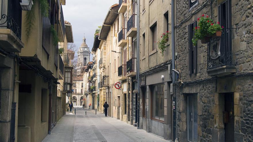 Una calle del casco antiguo de Oñate con al torres de la iglesia de San Miguel al fondo.
