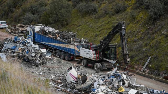 Los últimos restos del Alvia accidentado en Adamuz son depositados en los remolques de carga de camiones de gran tonelaje para sacarlos de la zona del siniestro.