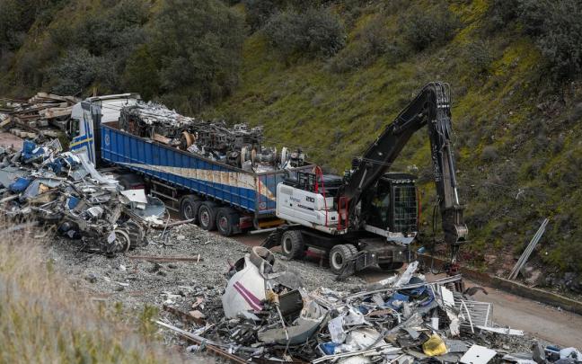 Los últimos restos del Alvia accidentado en Adamuz son depositados en los remolques de carga de camiones de gran tonelaje para sacarlos de la zona del siniestro.