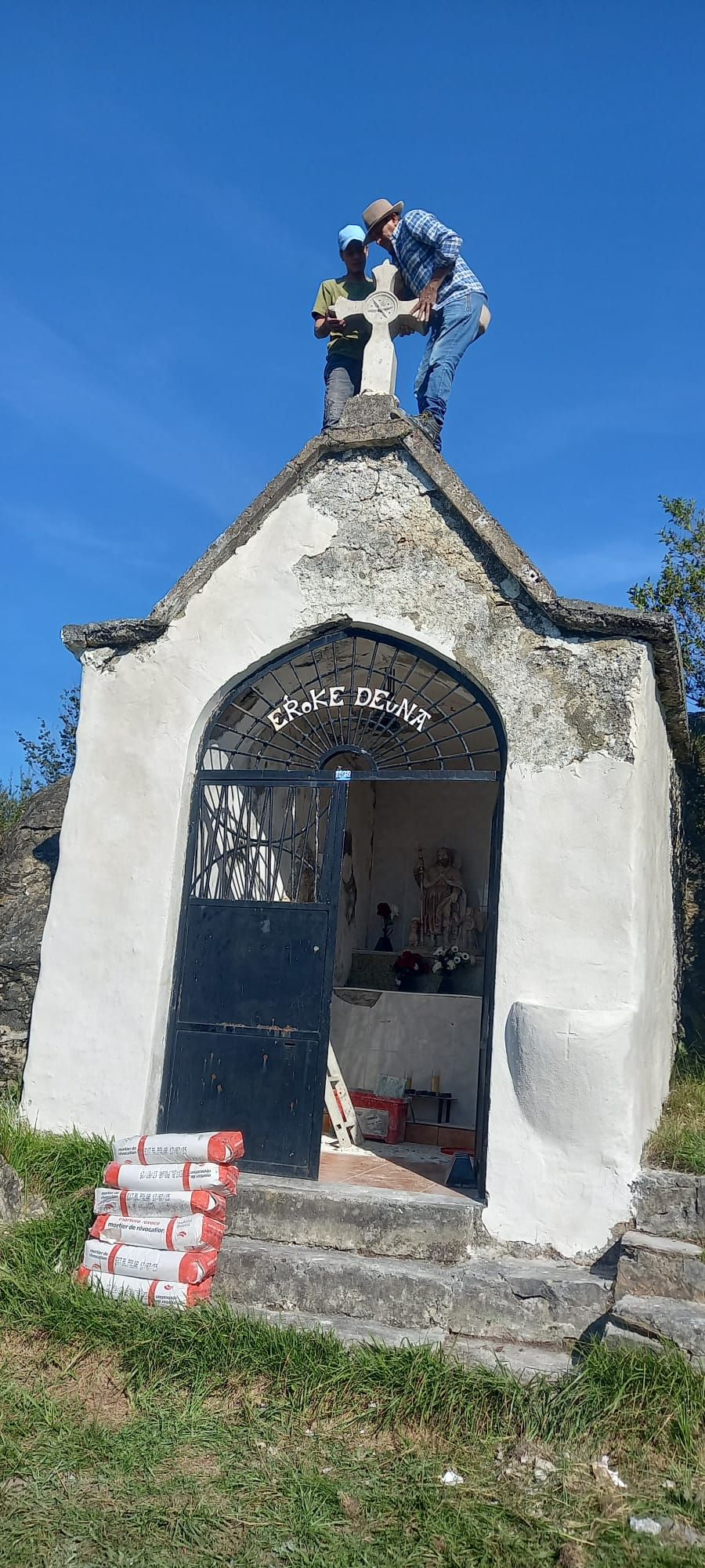 Trabajos para colocar la cruz en la ermita