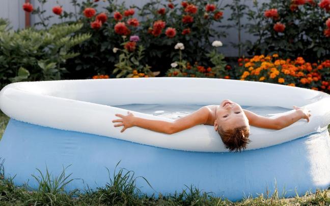 Un niño disfruta de un baño en una piscina hinchable.
