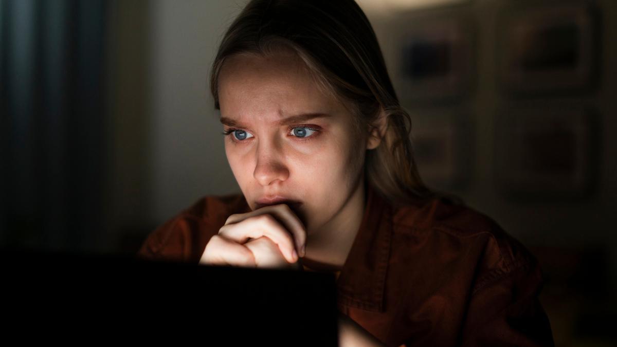 Una joven espera con interés la respuesta que busca en la pantalla.