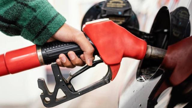 Una persona repostando en una gasolinera.