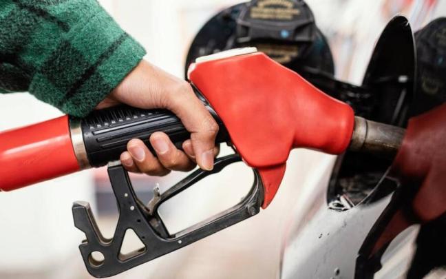 Una persona repostando en una gasolinera.