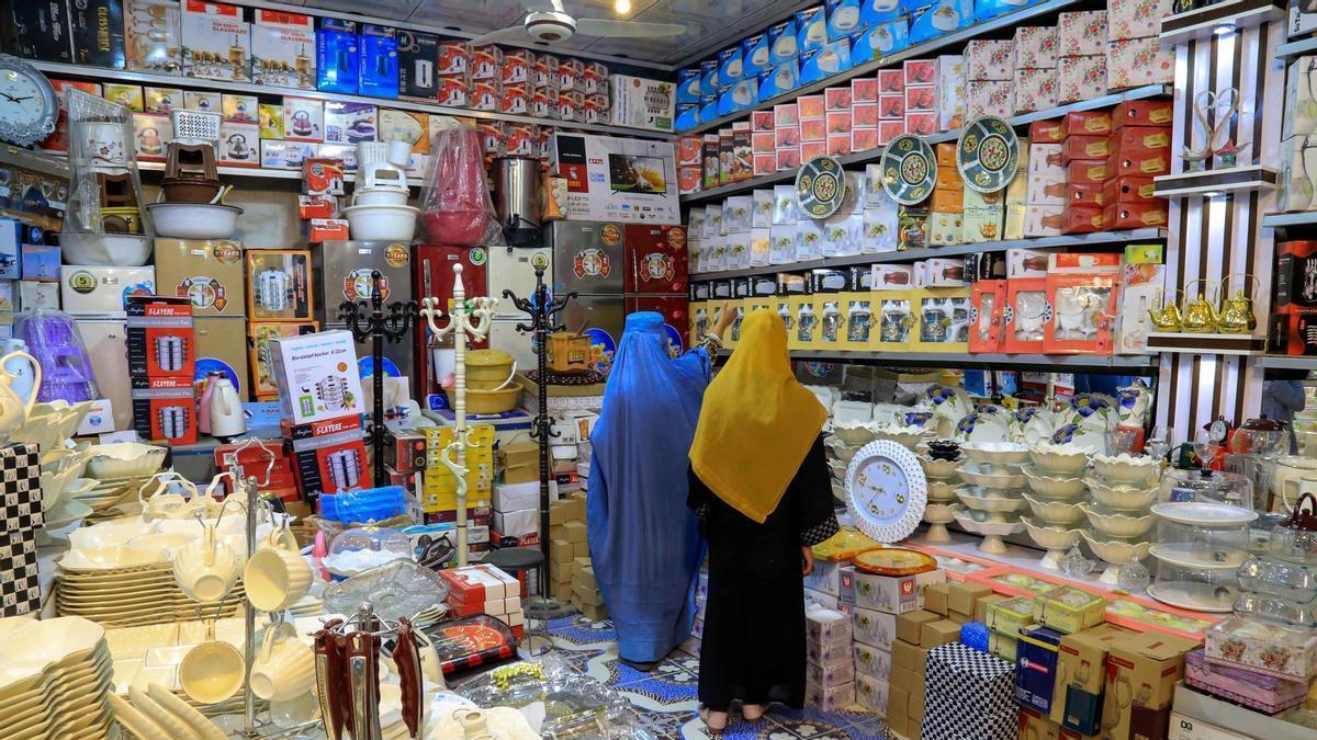 Dos mujeres compran accesorios de cocina en vísperas del segundo aniversario de la toma de Kabul.