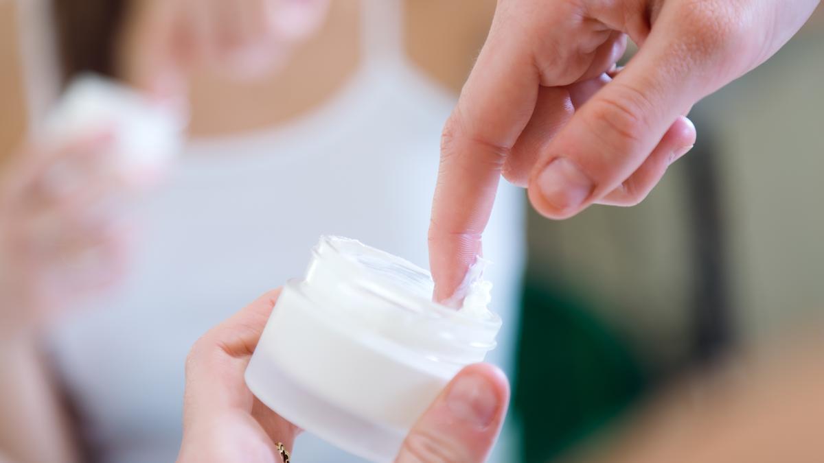 Primer plano de las manos de una chica con su crema facial.