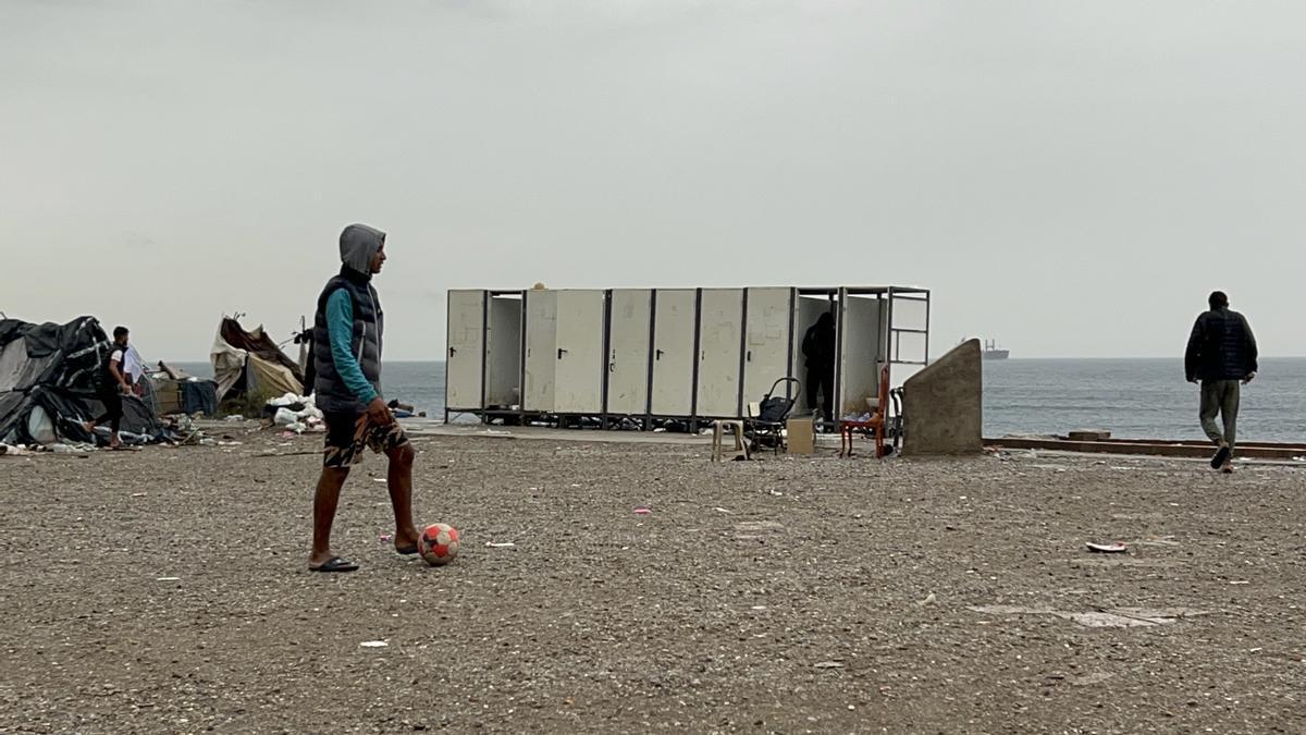 Varios migrantes esperan a ser trasladados en la explanada del Guano.