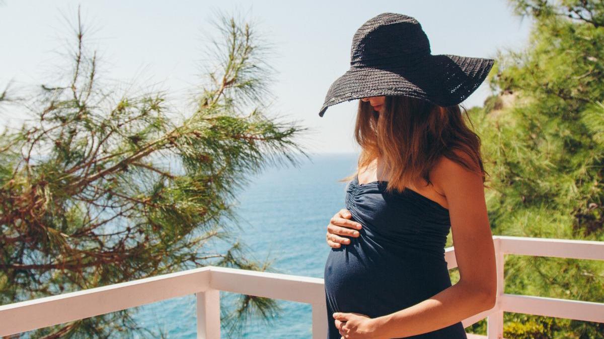 Mujer embarazada disfruta del verano en un destino de playa.