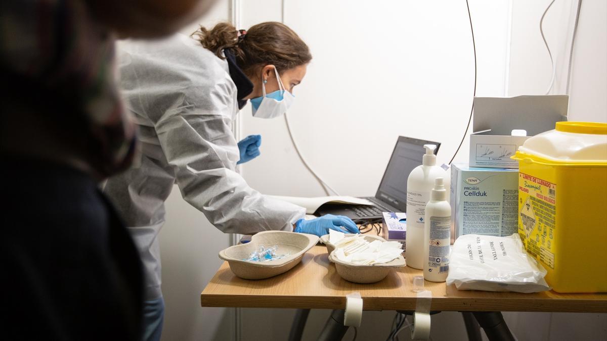 Una enfermera atiende a un paciente antes de ponerle la vacuna contra la gripe.