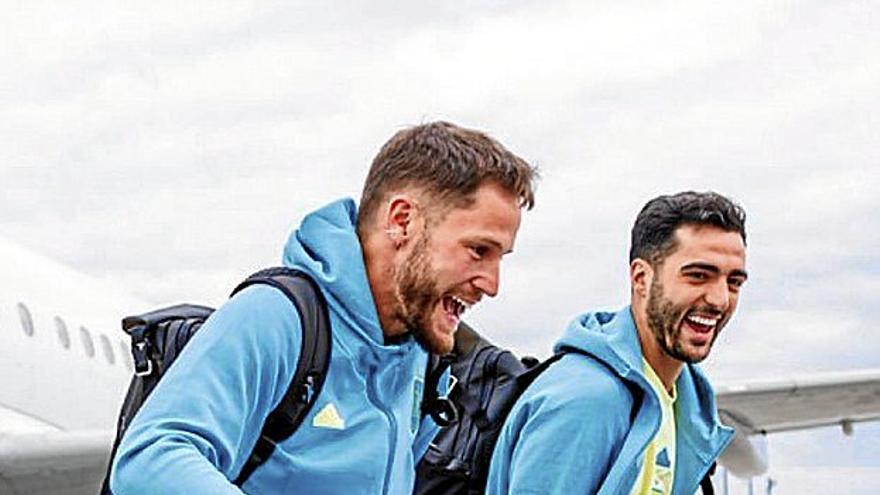 Álex Remiro y Mikel Merino se ríen mientras vbajan del avión, ayer en el aeropuerto de Berlín.