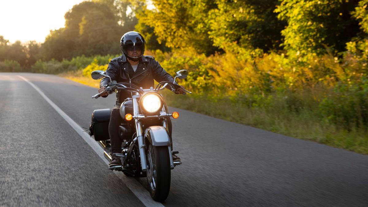 Un hombre conduce una motocicleta por carretera.