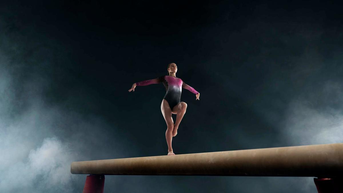 Gimnasta sobre una viga de equilibrio.