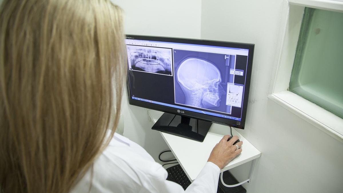 Una doctora observa los resultados de una prueba diagnóstica consistente en una radiografía mandibular.