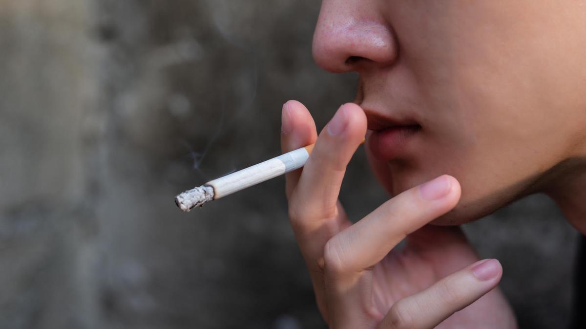 Un menor fumando un cigarrillo a escondidas.