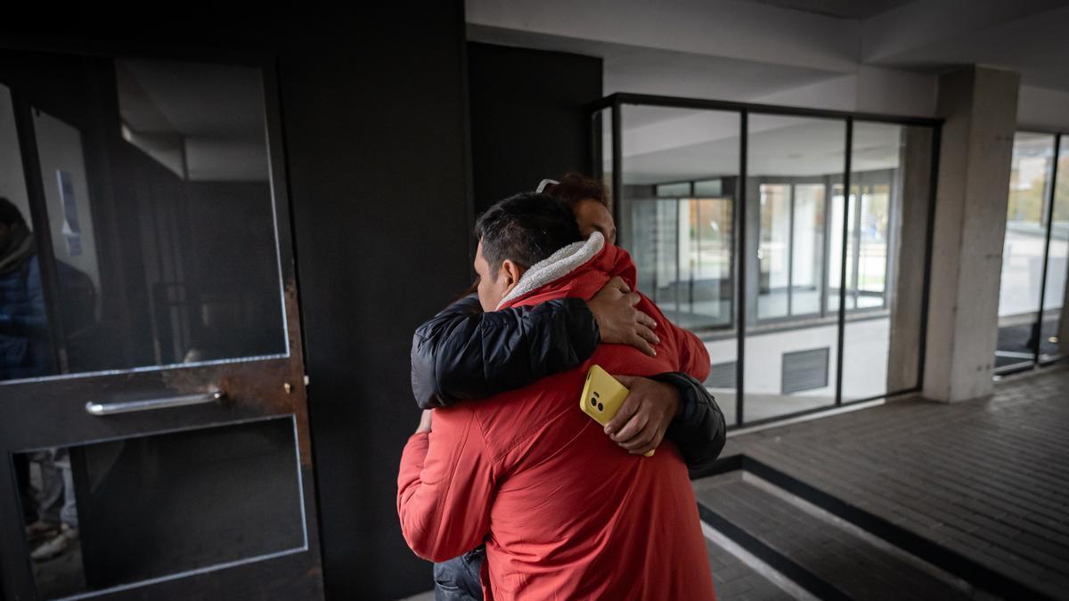 Una mujer abraza al padre de la joven asesinada junto a su hija en Carabanchel.