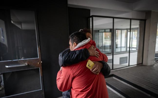 Una mujer abraza al padre de la joven asesinada junto a su hija en Carabanchel.