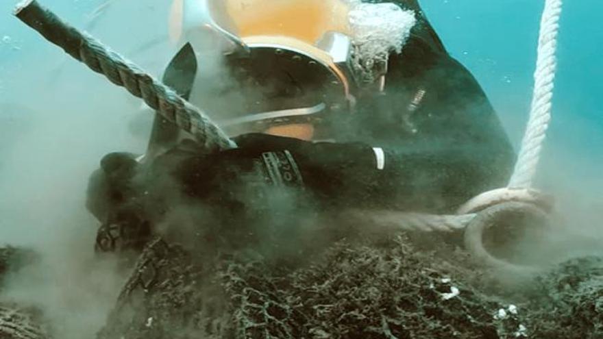 Un voluntario trabajando para sacar una red del fondo marino.