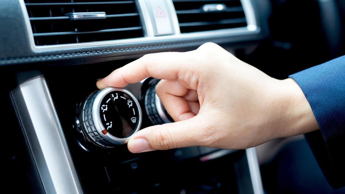 Una persona regula la salida del aire acondicionado