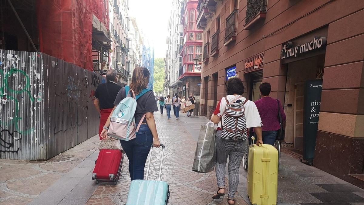 Varios turistas con sus maletas.