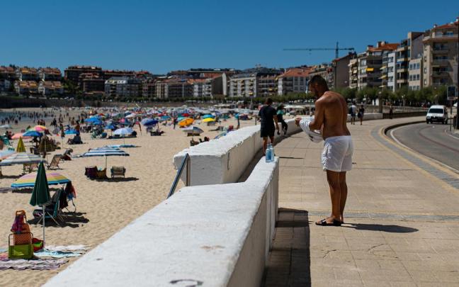 Una persona se cambia de ropa en el paseo marítimo
