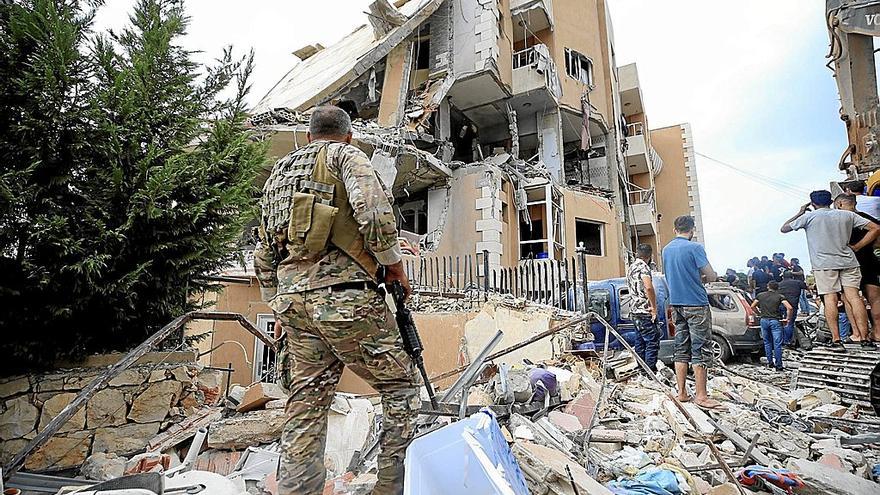 Un grupo de libaneses observan el estado en que quedó un edificio tras el ataque israelí sobre Barja, al sur de Beirut.