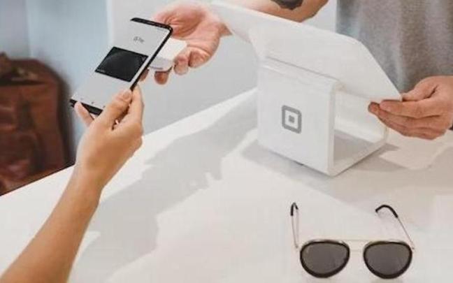 Dos personas realizan un pago 'contactless' Dos personas realizan un pago 'contactless'