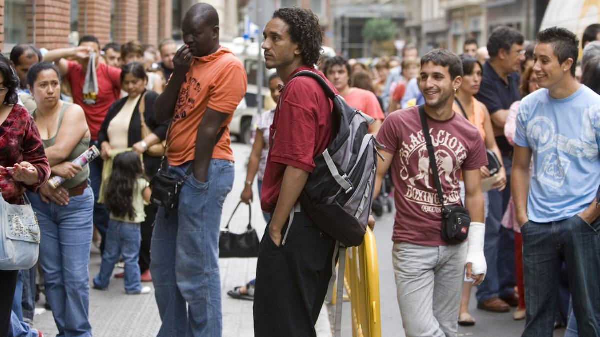 Decenas de personas de origen extranjero haciendo cola para tramitar sus papeles