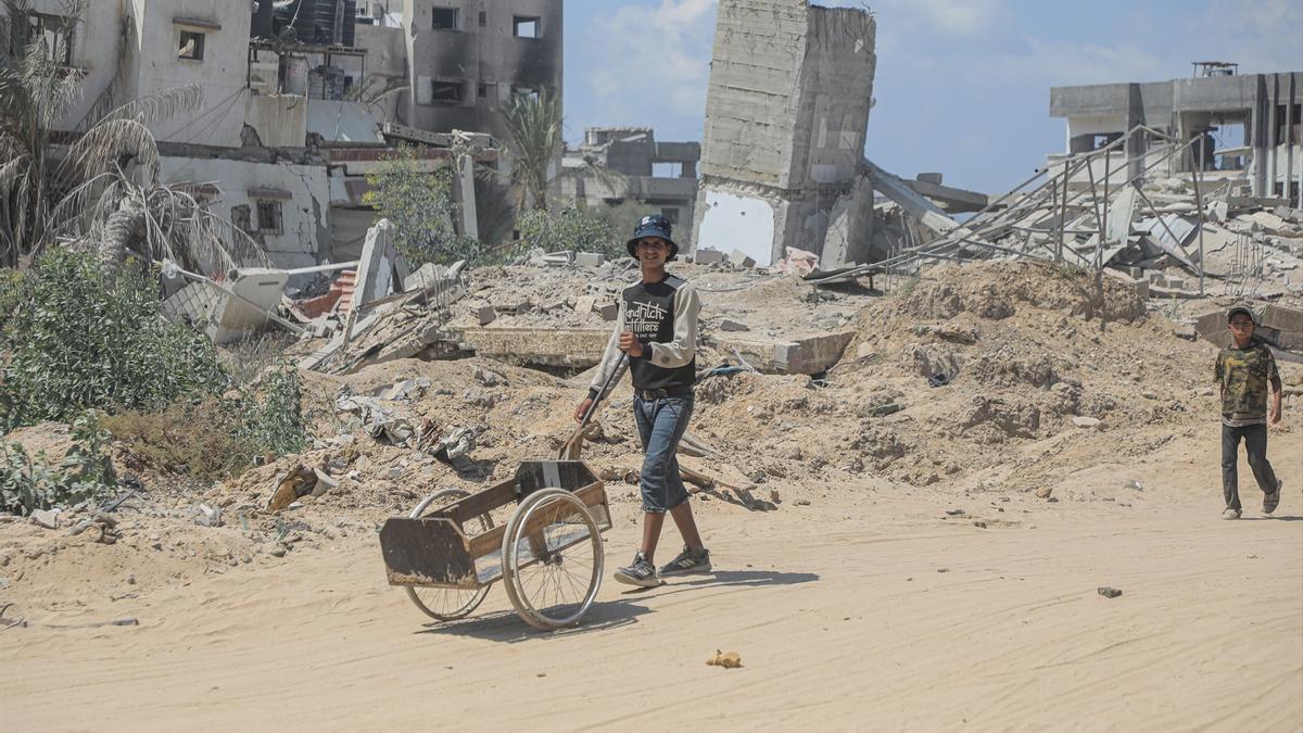 Palestinos entre los escombros de edficios destruidos en Jan Yunis.