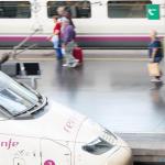 Viajeros con maletas en una estación de trenes.