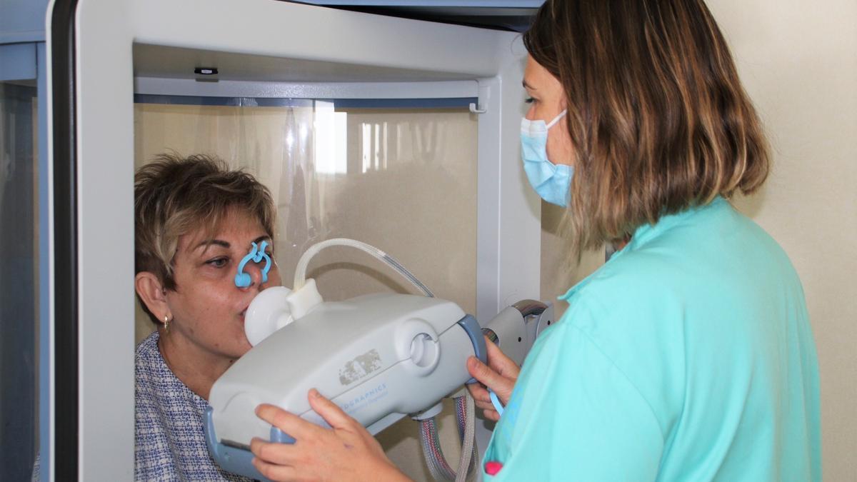 Una sanitaria realiza una prueba respiratoria a una mujer.