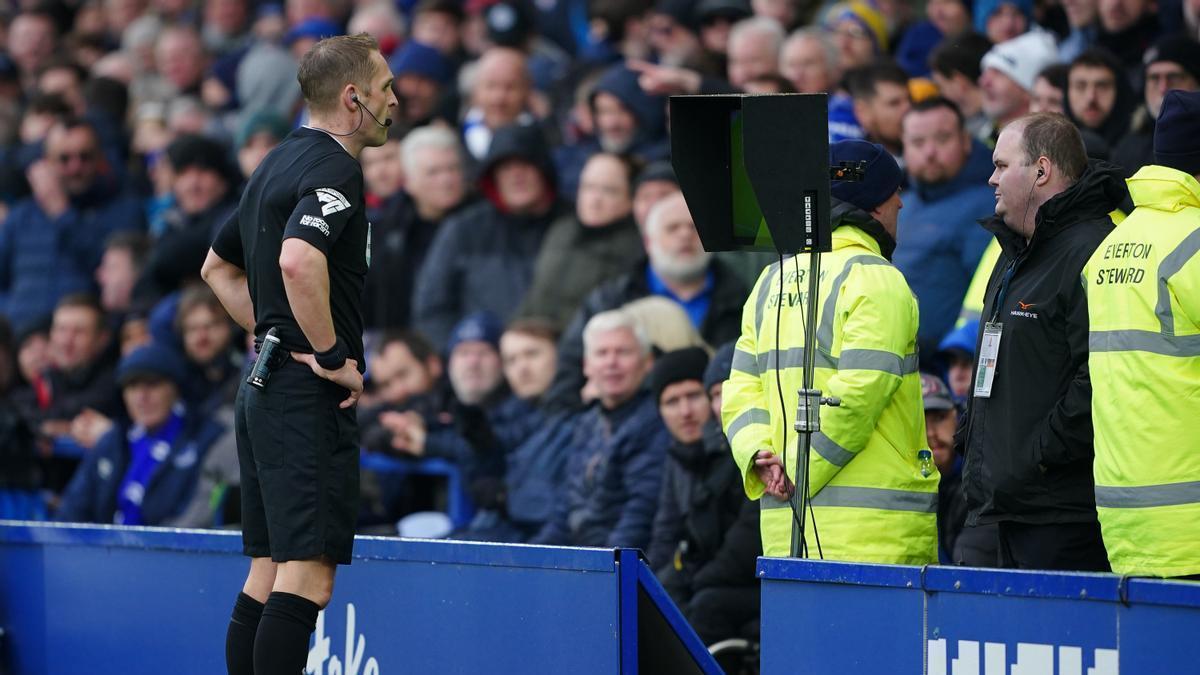 Un árbitro observa el VAR durante un partido entre el Everton y el West Ham United