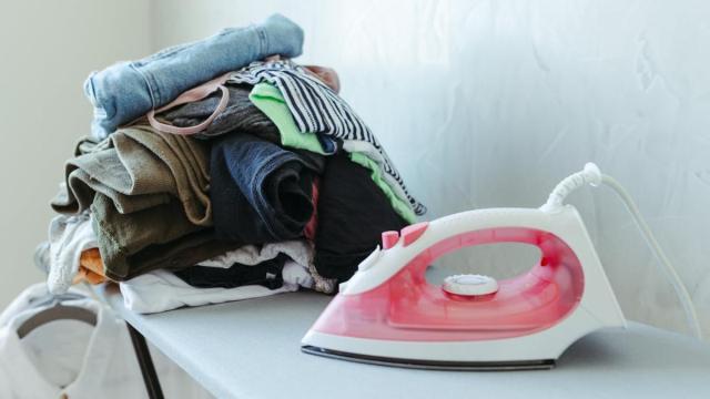 Una plancha con un conjunto de ropa al lado