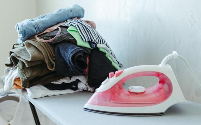 Una plancha con un conjunto de ropa al lado