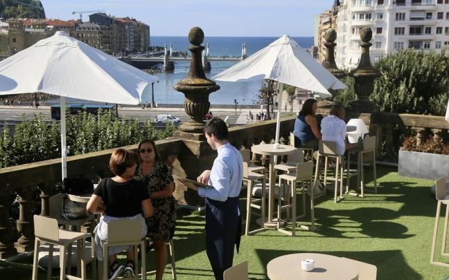 Un camarero atiende a unas clientas en un terraza de Donostia