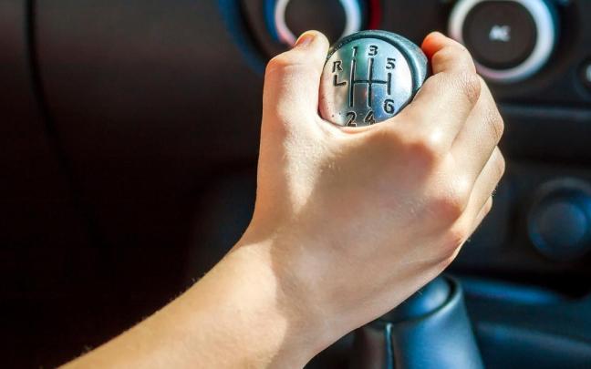 Un conductor sostiene una palanca de cambios.