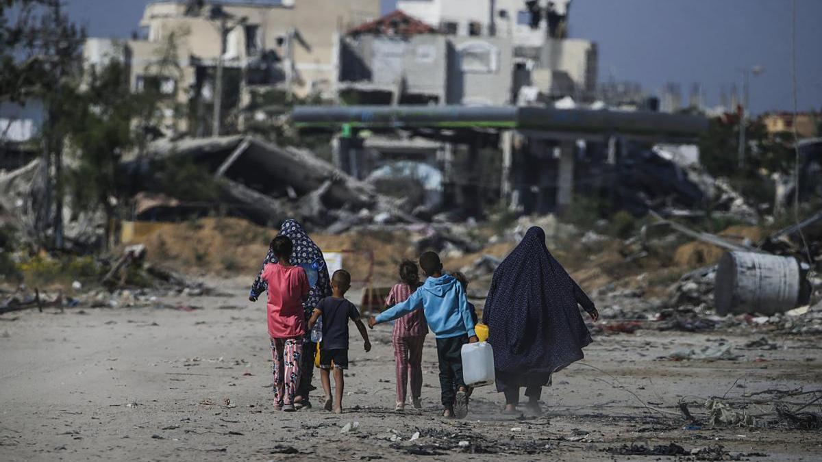 Una familia de desplazados entre las ruinas provocadas por los bombardeos en Jan Yunis.