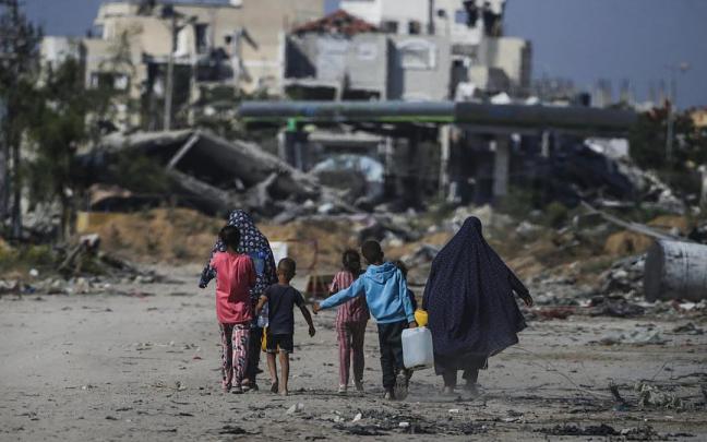 Una familia de desplazados entre las ruinas provocadas por los bombardeos en Jan Yunis.