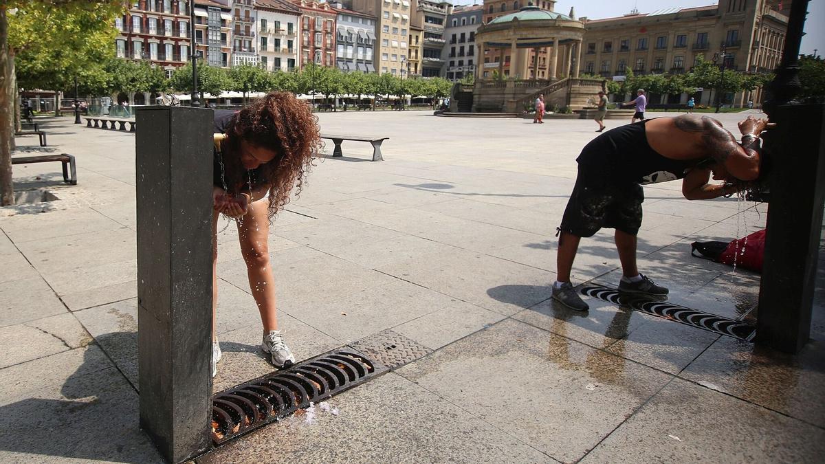 Varias personas se refrescan en la Plaza del Castillo (Iruñea) por las altas temperaturas.