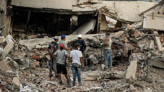 Personas participan en labores de búsqueda en un edificio afectado por el terremoto.