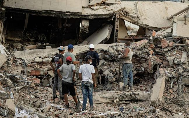 Personas participan en labores de búsqueda en un edificio afectado por el terremoto.