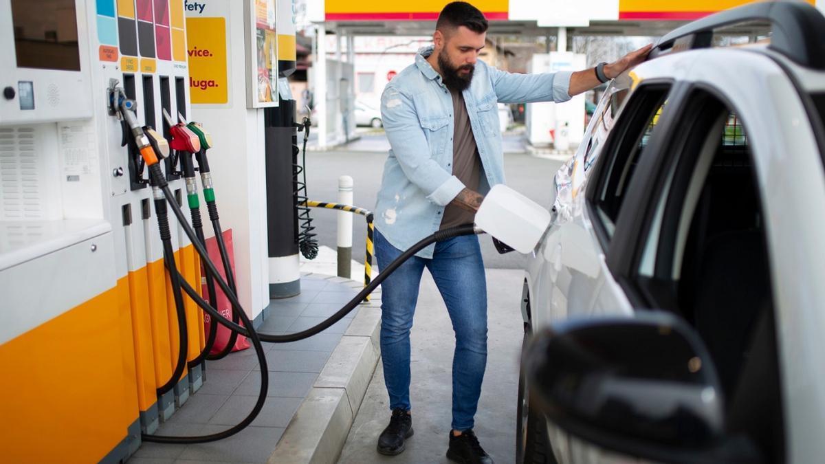 Un hombre reposta en una gasolinera.