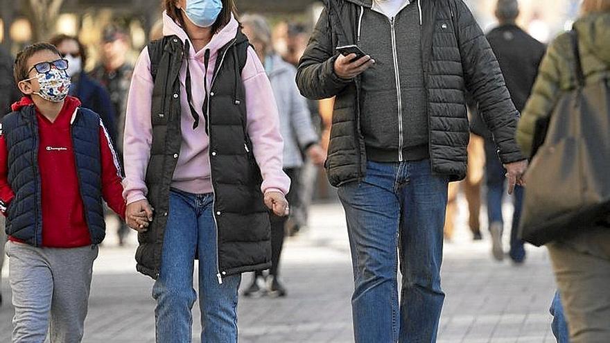 Una familia pasea con la mascarilla por el covid. | FOTO: RUBEN PLAZA