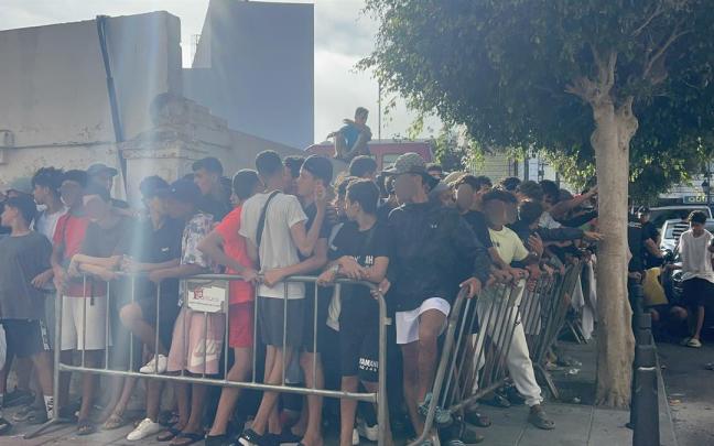 Un grupo de menores espera a las puertas de la Jefatura Superior de Policía de Ceuta para que les registren, 7 de agosto de 2026, en Ceuta.