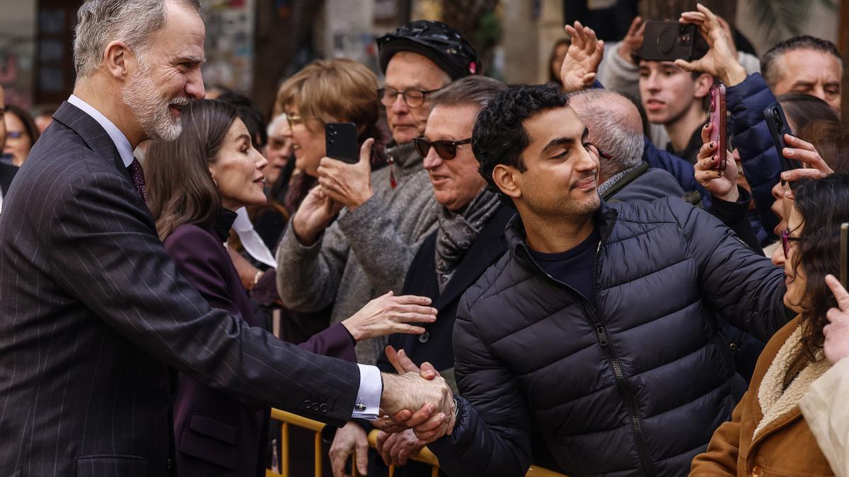 El rey Felipe VI y la reina Letizia saludan a la gente que les espera a su llegada a Valencia.