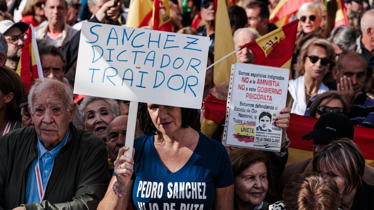 Una participante en la marcha muestra un cartel contra Pedro Sánchez.