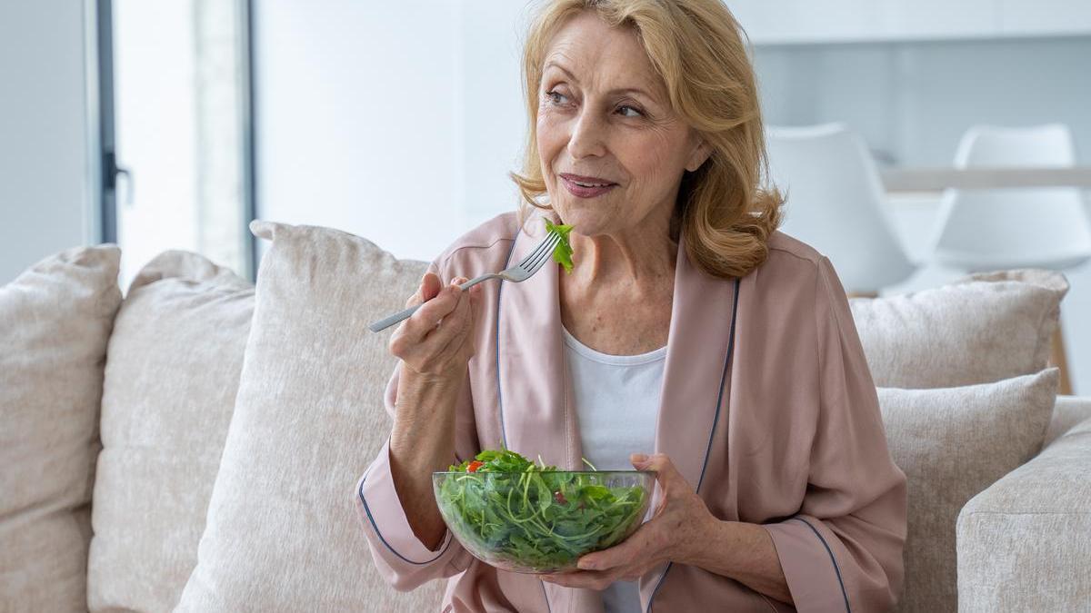 Señora come una ensalada.